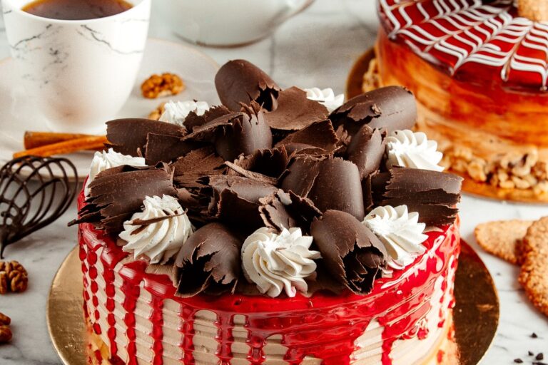 side-view-fruit-cake-topped-with-chocolate-curl-whipped-cream-table-served-with-tea (1)